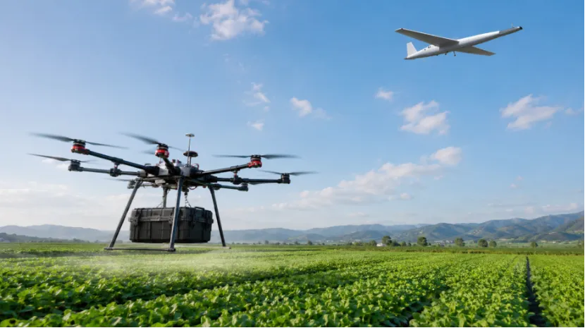 Multi-rotor drone carrying a heavy payload over a green field with a fixed-wing drone above